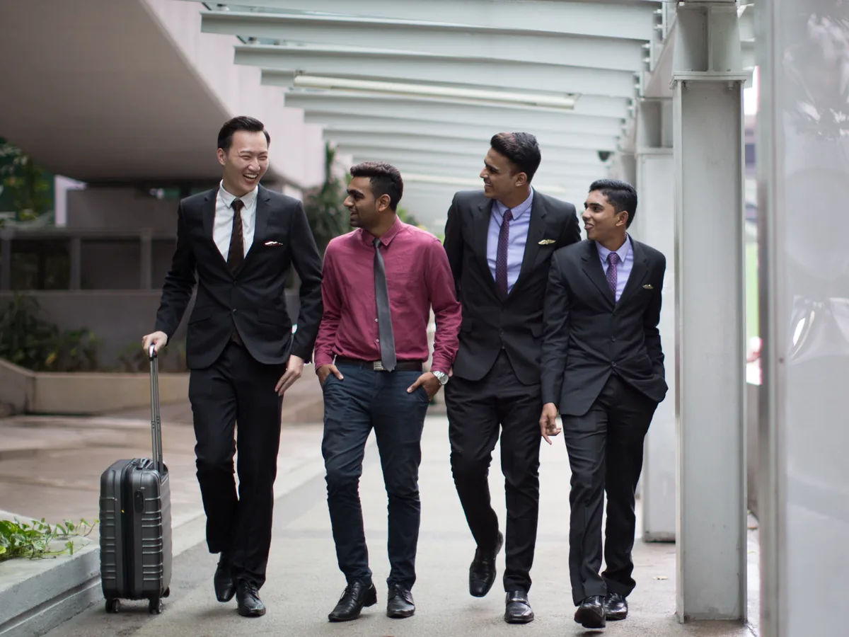 IETA students in business attire walking together with cabin luggage